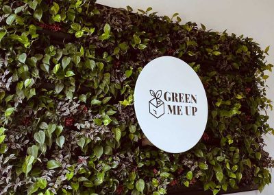 Pflanzenwand mit Logo "Green me up"